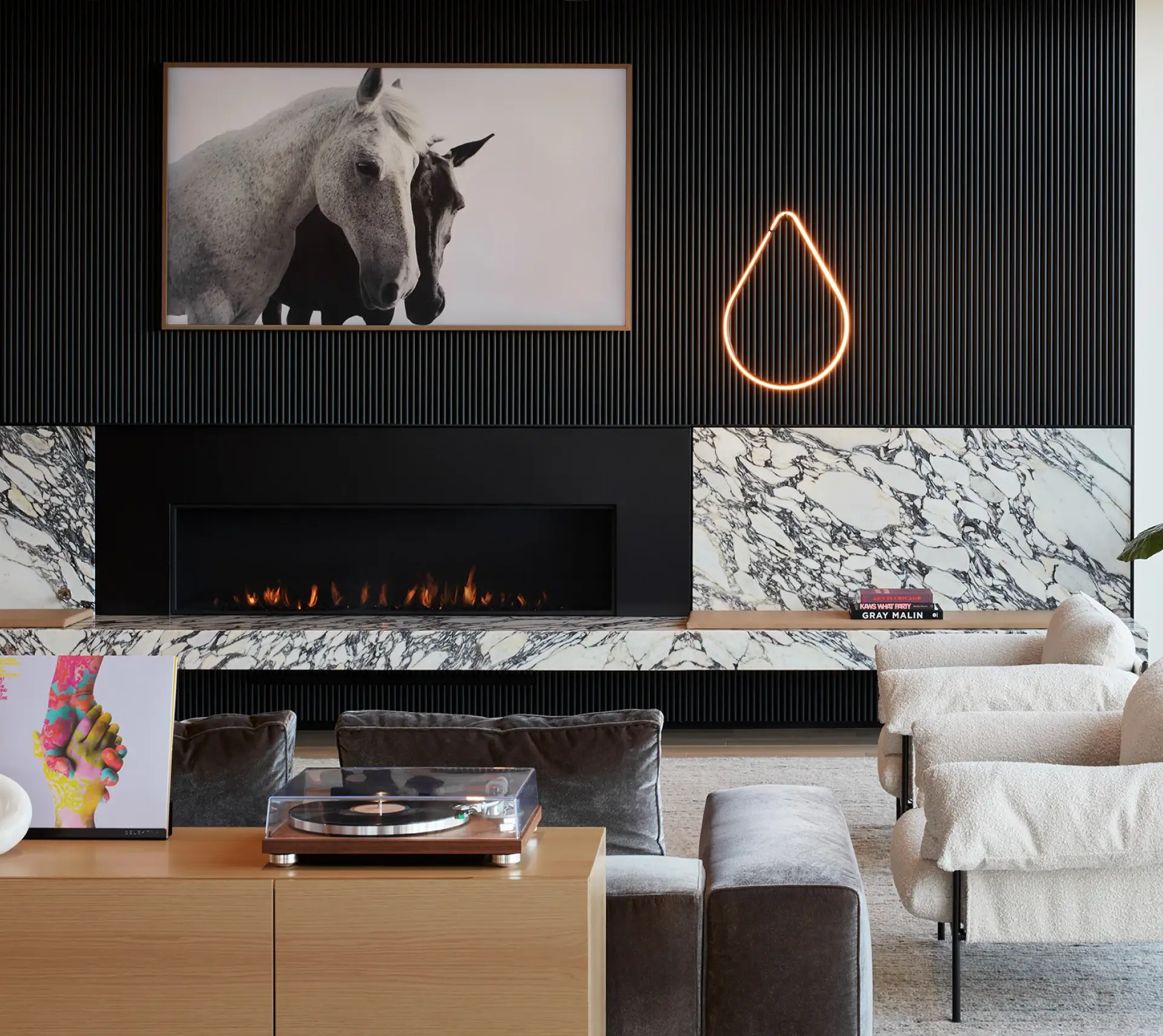 Cozy interior lounge with marble fireplace, horse artwork, and stylish modern seating arrangement